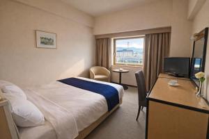 a hotel room with a bed and a window at The Celecton Fukushima in Fukushima