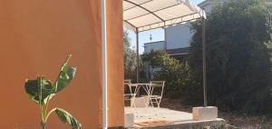 a patio with an umbrella and a table and chairs at Piccolo Paradiso Crotone in Casa Margherita