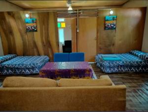 a room with couches and a table and blue chairs at Anjung Afilia 1 in Kuala Kangsar