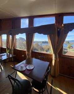 a dining room with a table and chairs and large windows at HOTEL CASAGRANDE con estacionamiento EXCLUSIVO y estamos a 50 MTS del Terminal de Buses in Valdivia