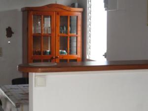 a kitchen with a wooden cabinet with glass doors at Mon Repos in Sainte-Luce +2 photos