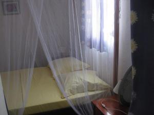 a bedroom with a bed with a plastic curtain at Mon Repos in Sainte-Luce
