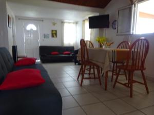 a living room with a table and chairs and a couch at Mon Repos in Sainte-Luce