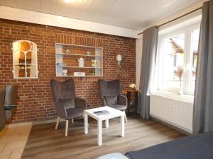 a living room with chairs and a brick wall at fewo1846 - Hofzimmer - ländlich gelegene Auszeit für zwei Personen in Handewitt