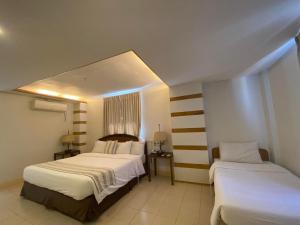 a hotel room with two beds and a window at Metro Vigan Inn MAIN in San Vincente