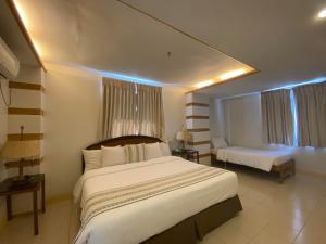 a hotel room with a large bed and a couch at Metro Vigan Inn MAIN in San Vincente +9 photos