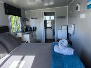 a bedroom with a bed with a towel animal on it at Raglan Seaview Cabin in Raglan +8 photos