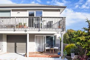 a house with a balcony with a table and chairs at Stylish Lyttelton Studio Free Parking in  Lyttelton