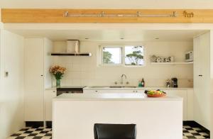 a kitchen with a counter with a bowl of fruit on it at Artist's Beach House - Waterfront in Murdunna +35 photos