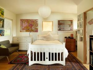 a bedroom with a white bed and a couch at Artist's Beach House - Waterfront in Murdunna