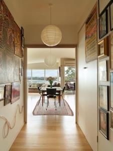 a dining room with a table and a view of the ocean at Artist's Beach House - Waterfront in Murdunna