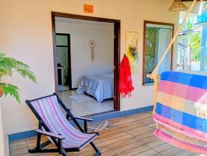 a patio with a chair and a bed in a room at Cantinho da Paz in Serra Grande