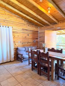 a dining room with wooden walls and a table and chairs at Cabaña Manzano Historico Punta Negra Lodge 2 in Tunuyán