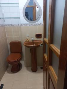 a bathroom with a toilet and a sink and a mirror at Casa Zudañes in Sucre
