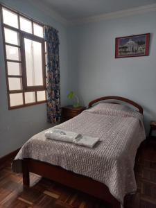 a bedroom with a bed with two towels on it at Casa Zudañes in Sucre