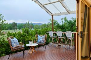 a porch with chairs and a table with a view at Coco's Bungalow in Mudgee