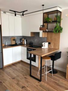 a kitchen with white cabinets and a wooden table at Z widokiem na Jaworzynę in Krynica Zdrój +16 photos