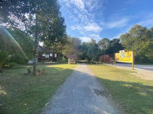 a dirt road next to a park with a sign at Anjung Afilia 1 in Kuala Kangsar