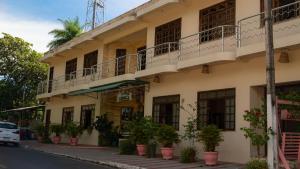 a building on the side of a street with potted plants at Pousada Cabocla - Centro de Alter in Alter do Chao