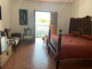 a bedroom with a bed and a television and a balcony at Antigua Mariana Hotel Boutique in Cedro
