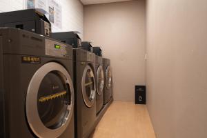 a row of washing machines in a laundry room at Heyy Seogwipo Hotel in Seogwipo