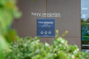 a sign on a wall in a store with trees at Heyy Seogwipo Hotel in Seogwipo +6 photos