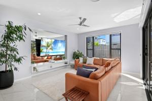 a living room with a couch and a flat screen tv at Sunshine Coast Escape | Beachside, Pool & Views in Kawana Waters