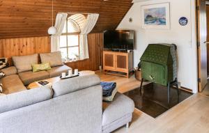a living room with a couch and a tv at Holiday Home Narssagsvej in Rømø