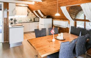 a kitchen and dining room with a wooden table and chairs at Holiday Home Narssagsvej in Rømø
