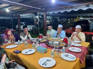 a group of people sitting around a table eating at Anjung Afilia 1 in Kuala Kangsar