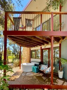 a house with a large deck with a living room at The Treehouse at Sellicks Hill in Sellicks Hill