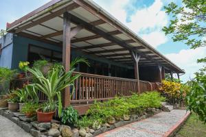 a house with a deck with plants in front of it at Hidden Secret in Gros Islet