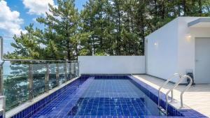 a swimming pool on the balcony of a house at Yeongdeok Full Moon Pool Villa in Yŏngdŏk