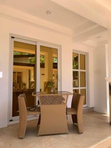 a dining room table with chairs and a table and windows at Turtle's Cavern Oceanfront Resort in San Juan