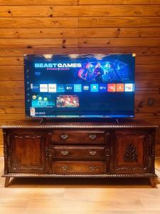 a flat screen tv sitting on top of a wooden dresser at Chalés La Montagna in Santa Teresa