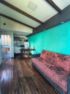 a living room with a red couch and a blue wall at Casas Container Cassino in Rio Grande