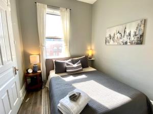 a small bedroom with a bed with a window at Walk to Wrigley 3BR1BA Sleeps 8 Free Parking in Chicago