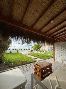 a patio with a table and a straw roof at Costa Nueva Hotel in Zorritos