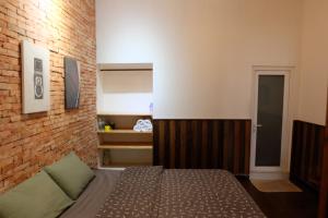 a bedroom with a bed and a brick wall at Villa Aqua Da Lat in Da Lat +17 photos