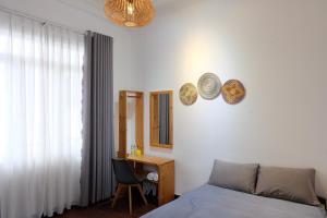 a bedroom with a bed and a desk and a chair at Villa Aqua Da Lat in Da Lat