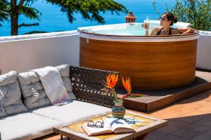 a woman in a jacuzzi tub on a patio at Villa Algarrobos in Praiano
