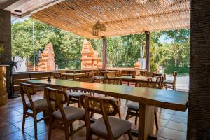a restaurant with tables and chairs and a large window at Sandat Mas Uluwatu in Uluwatu