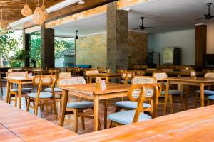 a restaurant with wooden tables and chairs at Sandat Mas Uluwatu in Uluwatu