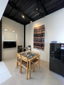 a dining room with a table and chairs and a screen at Casa de Lisa in Tjakranegara