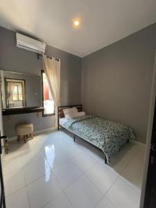 a small bedroom with a bed and a window at Casa de Lisa in Tjakranegara
