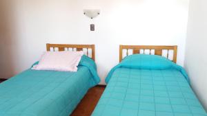 two beds sitting next to each other in a room at Piezas con Baño Privado Economicas in La Serena
