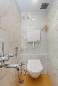 a white toilet in a bathroom with marble walls at Hotel Lexus7 in Mumbai