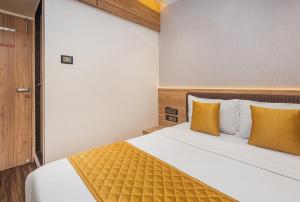 a bedroom with a large bed with yellow pillows at Hotel Lexus7 in Mumbai