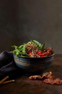 a bowl of salad sitting on top of a table at DEMIN VILLA HỘI AN - POOL & BBQ Gaden in Hoi An