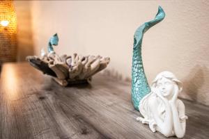 a figurine of a mermaid and a bowl on a table at La Sirena Pescadora in Corpus Christi